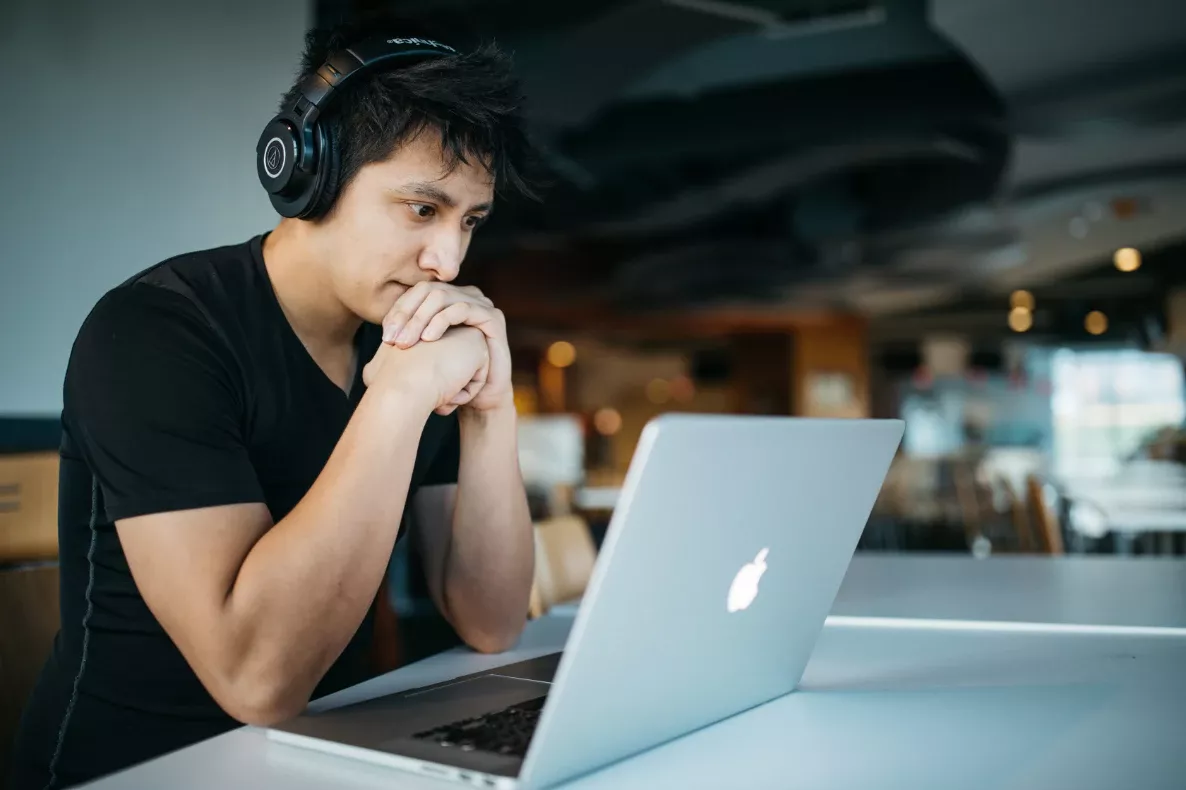 Person wearing headphones focused on a laptop